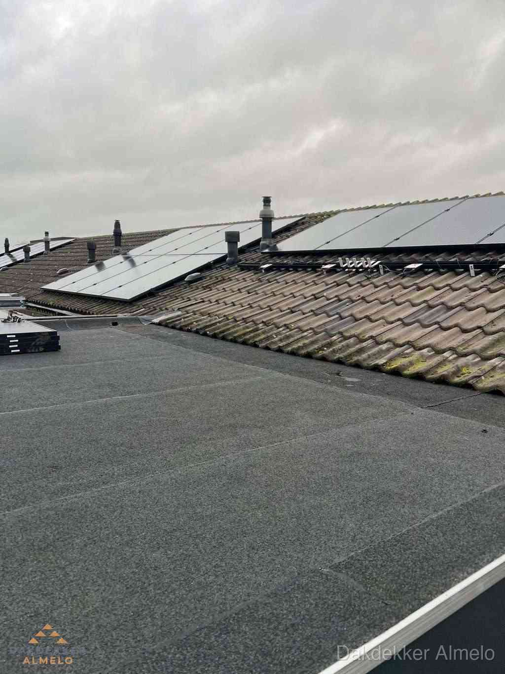 Bitumen dakbedekking op plat dak met aansluitend pannendak en zonnepanelen in Almelo
