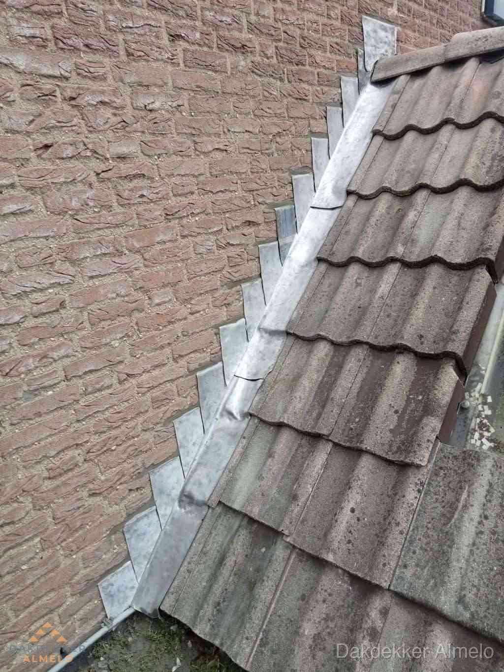 Loodslabben langs dakaansluiting bij bakstenen muur in Almelo